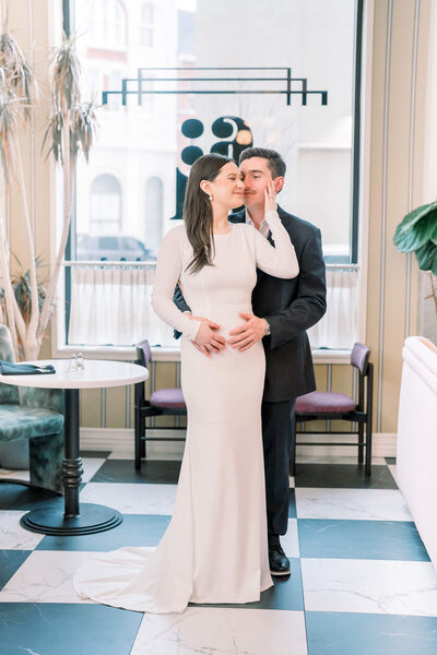 Elegant couple embraces in a modern venue, captured by Jackson MS Wedding Photographer for a timeless love story.