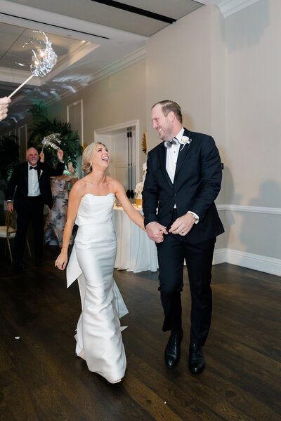 Bride and groom holding hands laughing together