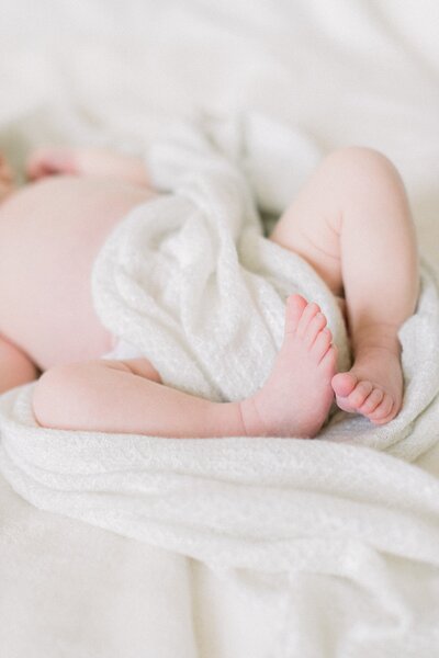 baby feet swaddled in white blanket
