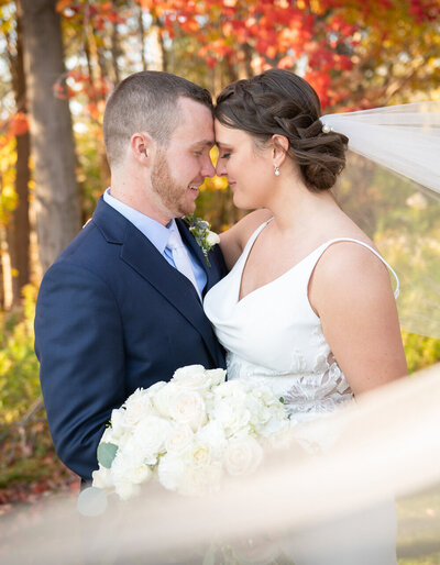 bride and groom embrace while smiling at camera