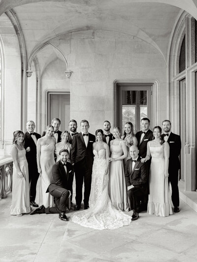 Black and white group photo of bride and groom with their wedding party