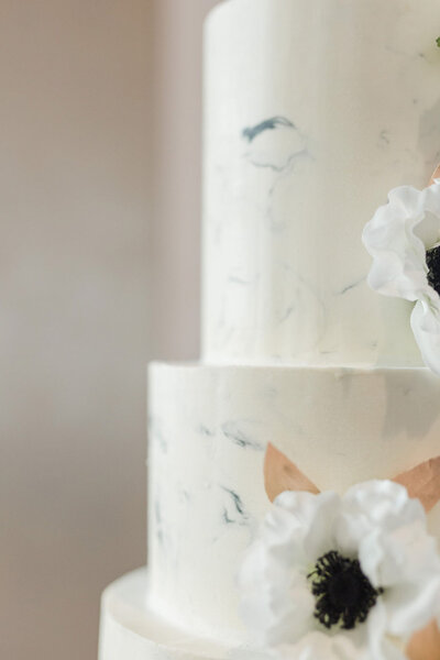 White wedding cake with marble design and white flowers