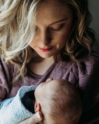 mother holding newborn baby during  newborn photoshoot in Pittsburgh