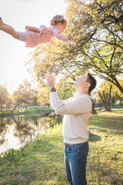 father tossing daughter up in the air
