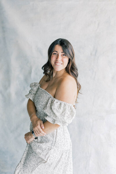 women photographer smiling at camera holdings albums in hand knoxville tennessee newborn photographer