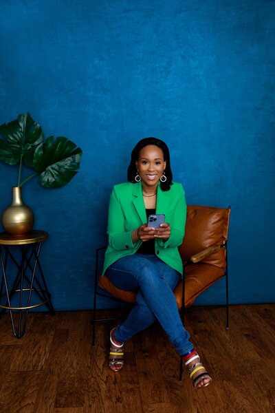 Charmaine Green Forde CEO of Chapter tOO™ smiling at camera holding phone
