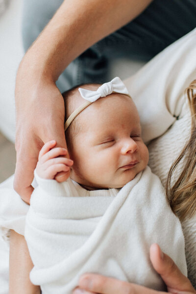 mother holding her newborn baby wrapped in swaddle