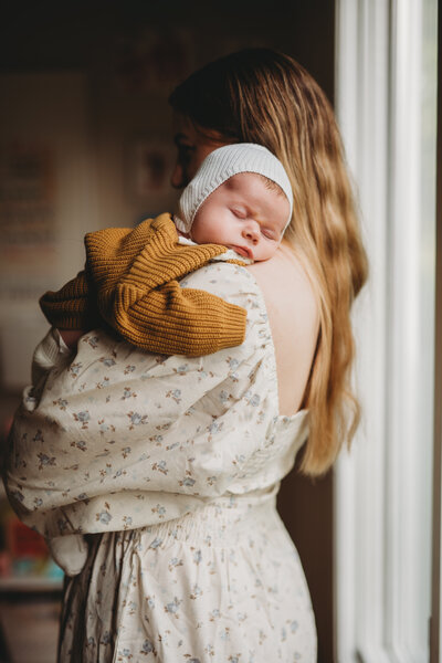 A delicate newborn gazes up with wonder while resting in their parent’s arms. Lifestyle newborn photography allows you to cherish these fleeting moments with soft, natural light and intimate in-home settings.