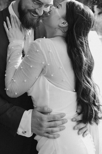 bride kisses groom on cheek