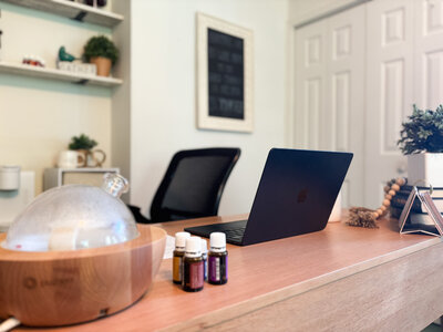 Essential oil diffuser and laptop in a bright and calming home office workspace
