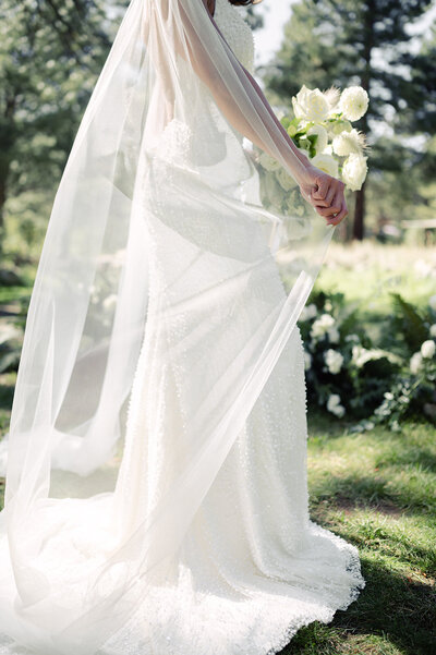 Bride holds her veil by her side at her wedding at Dancing Pines in Lake Tahoe.