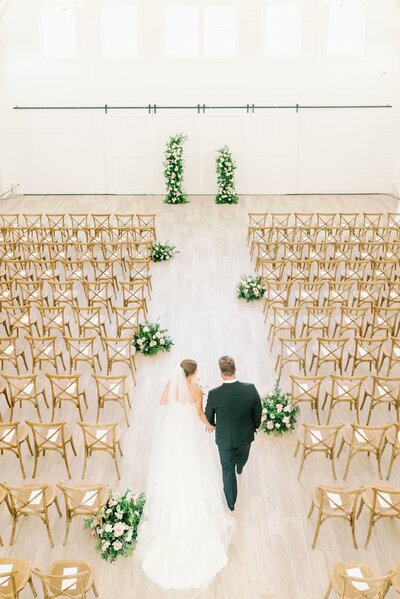 bride and groom walk down the aisle in the grand hall of Providence Vineyard