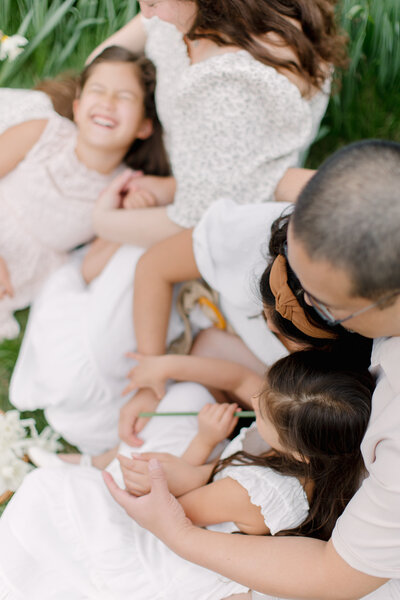 A photo taken above a family of five snuggling in a glassy field of daffodils