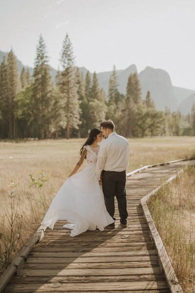 bride and groom walking on wooden bridge