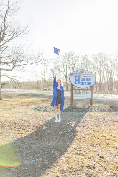 senior throwing grad cap into the air