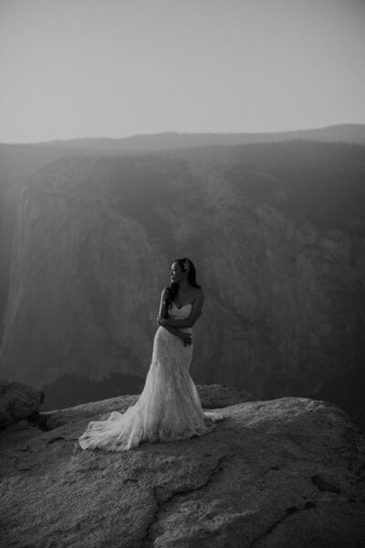 Bride stands in Yosemite National Park mountains
