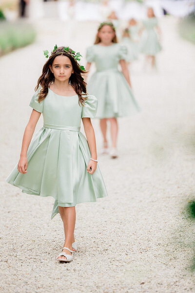 Flower girls wearing mint green dresses and floral crowns