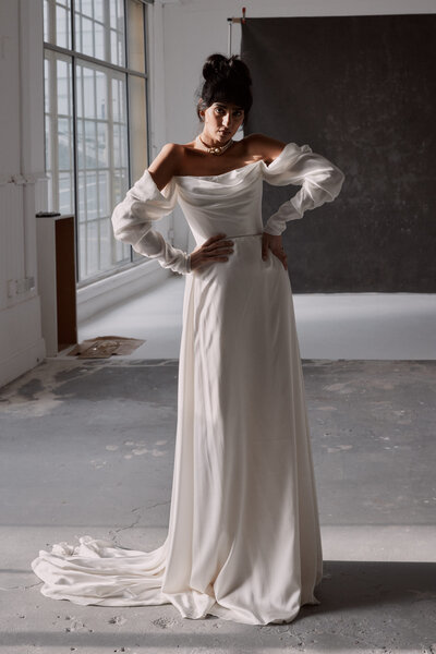 Bride wearing long-sleeved bridal top and silk flowing skirt separates by British wedding dress designer