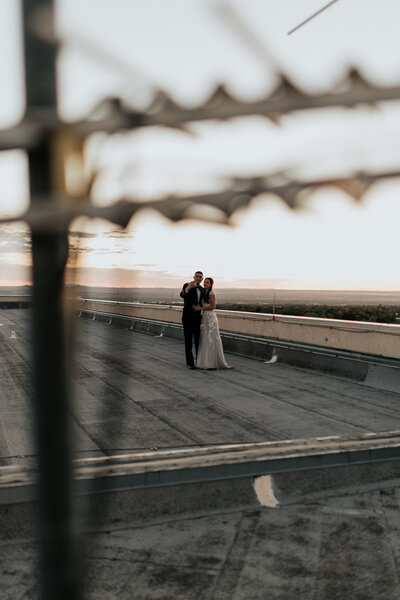bride and groom embracing on bridge