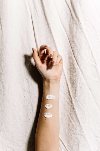 A woman's arm with smears of nourishing skincare products