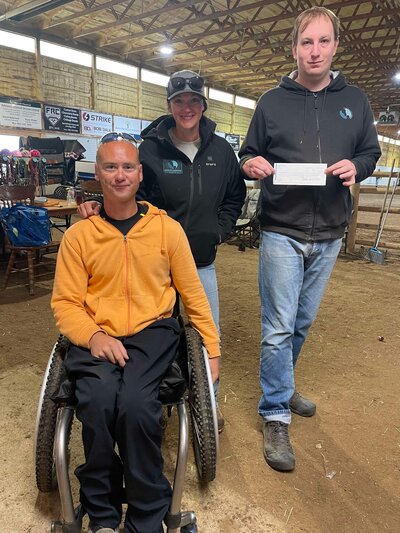 Mentors assisting a patient in a wheelchair at Spirit's Respite Ranch.