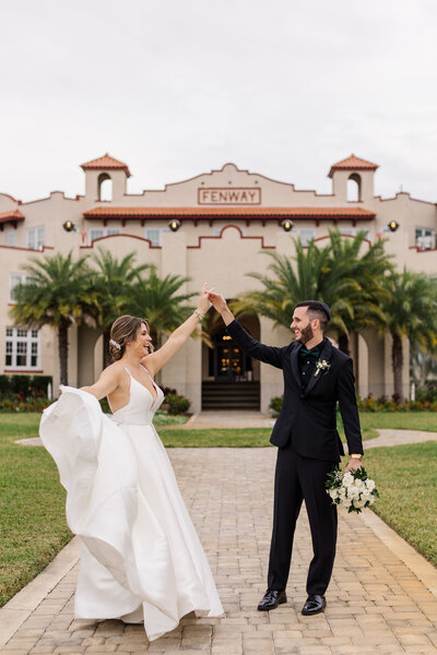 Bride and Groom twirling together in front of fenway hotel Florida taken by wedding photographer in Orlando, Blak Marie