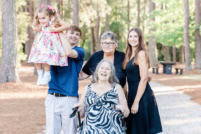 extended family posing together in wooded area during golden hour