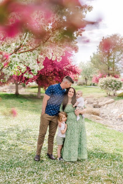 family hugging with Spring cherry blossoms around them 