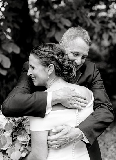 Father hugging emotional bride at their father-daughter first look in a Downtown Charlottesville wedding