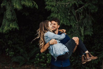 man holding woman in the woods