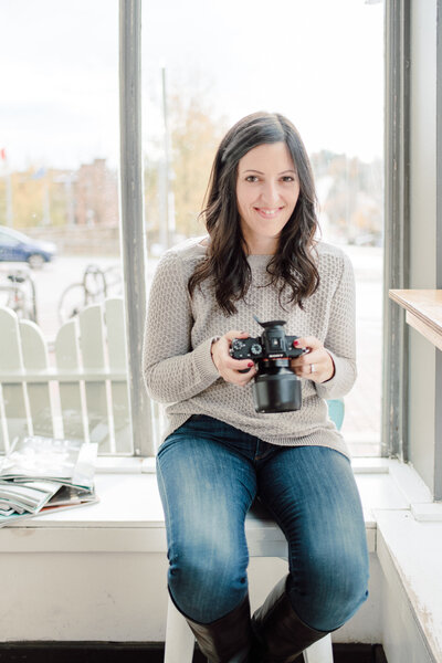 woman smiling and holding camera