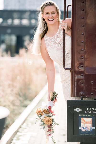Toronto Wedding Photographer - Bride Holding  Lovely bouquet hold on to train looking at the camera