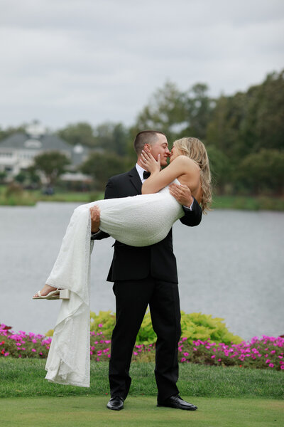 Groom swept Bride off her feet and she kisses him. Photo by Northern Virginia Photographer Alex McCormick.