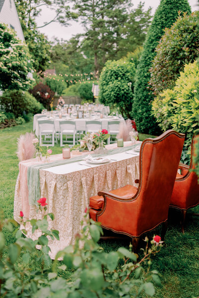 A plush chair behind a wedding reception table set up in a garden 