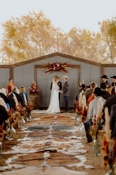 cowhide aisle at ranch wedding ceremony