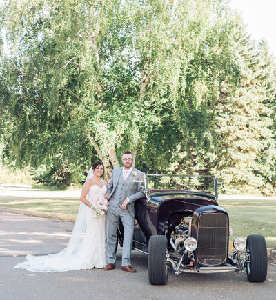 wedding photo of couple next to a model t convertible