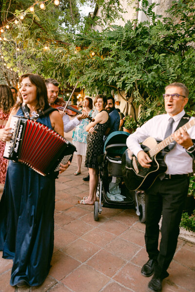 A candid wedding photo of the band playing during cocktail hour at laticastelli in Tuscany Italy