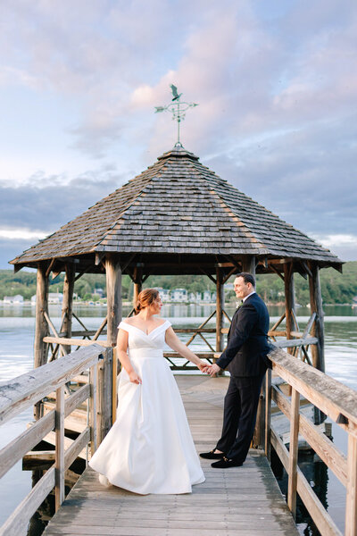 Bride and Groom standing on a dock holding hands