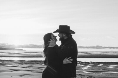 couple holding each other with a stunning Alaska landscape behind them