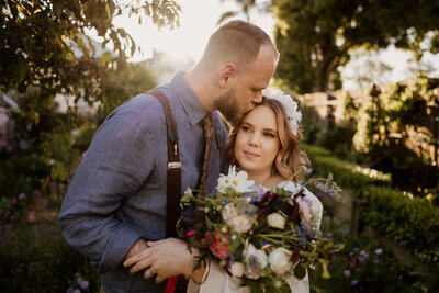 Couple having a cuddle and the groom is giving the bride a kiss on the forehead - Wedding photographer in Toowoomba