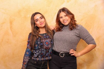 friends posing in front of a yellow/ gold backdrop