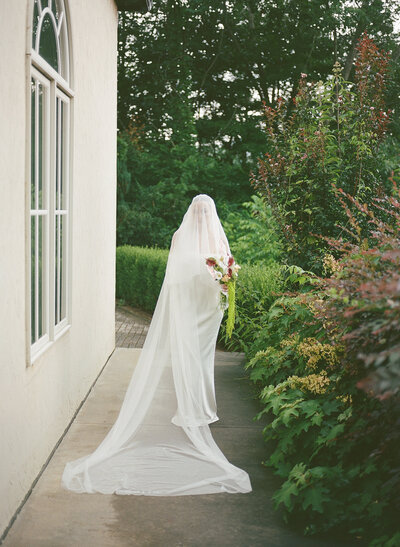 Soft light bridal portrait on a terrace overlooking Italian hills.