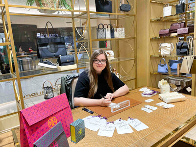 woman sitting at a table with calligraphy gift tags