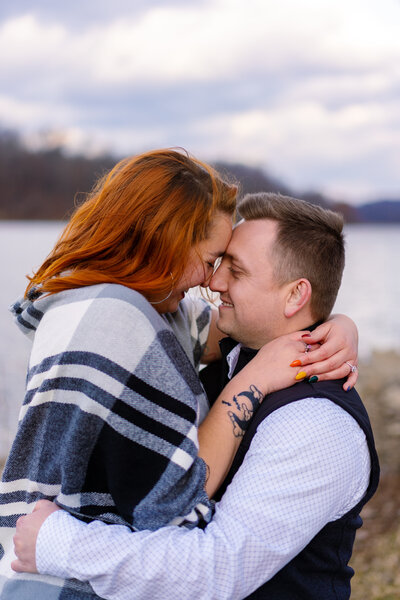 Engaged couple, Brooklin Mincone and Chris Esola, touch foreheads and smile as they embrace.