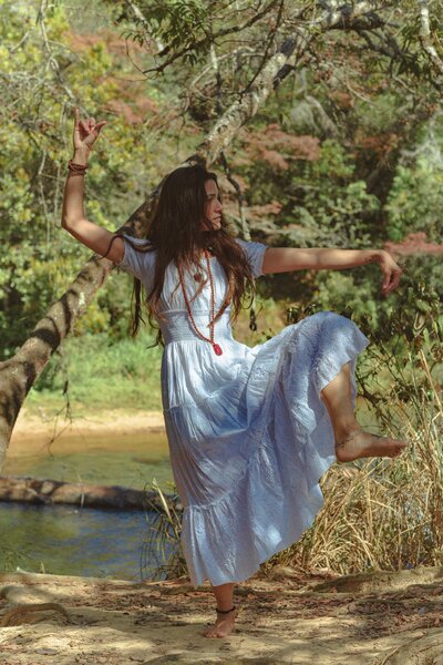 A woman gracefully adopts a standing yoga pose amidst the beauty of nature