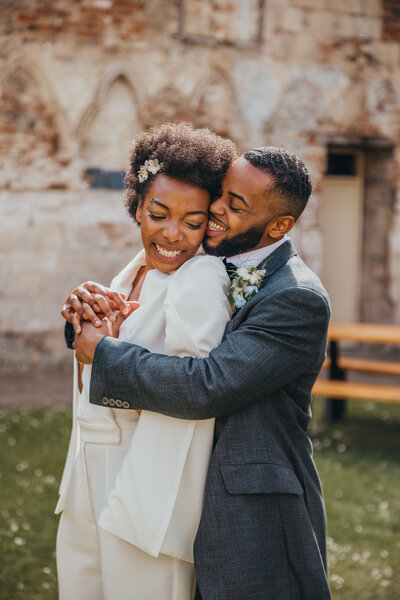 LGBTQ+ couple smile and embrace