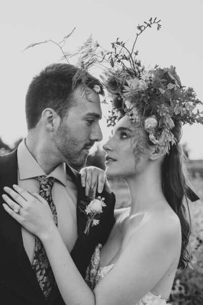 groom leans into bride wearing floral headpiece