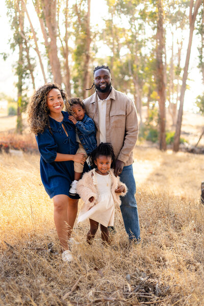 Family of four smiling together on woodland path at golden hour — Bay Area Photographer Services - Ellobelle Photography Family Photographer