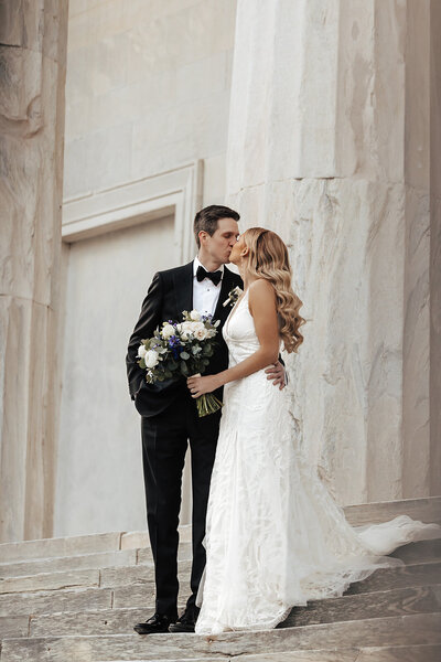 bride and groom kissing on the steps in philadelphia pa