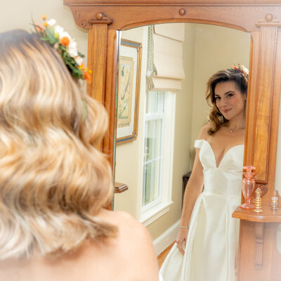 Bride looking into mirror and smiling
